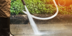 person-wearing-rainboots-pressure-washing-driveway-aeeec933df5148afa57457d6d1fe6aea